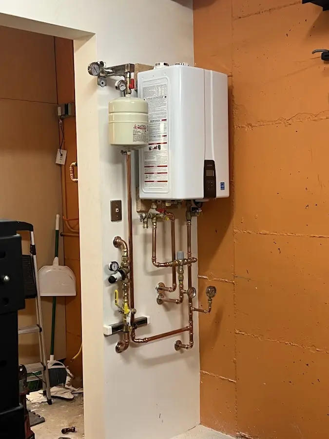 Plumbing technician inspecting water heater connections in Herndon